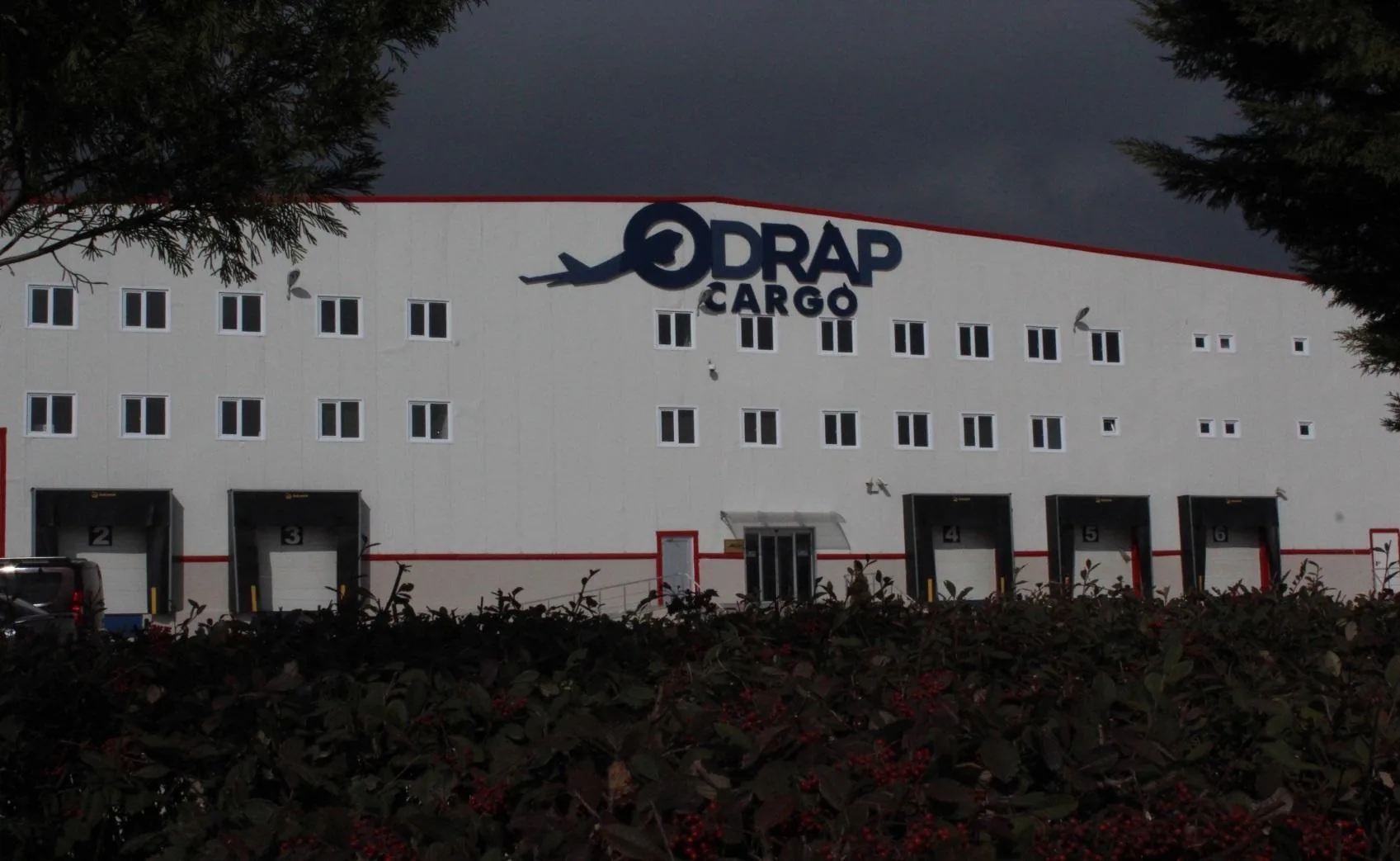 Alacakaranlıkta Odrap Cargo terminal binası ve cephedeki logo